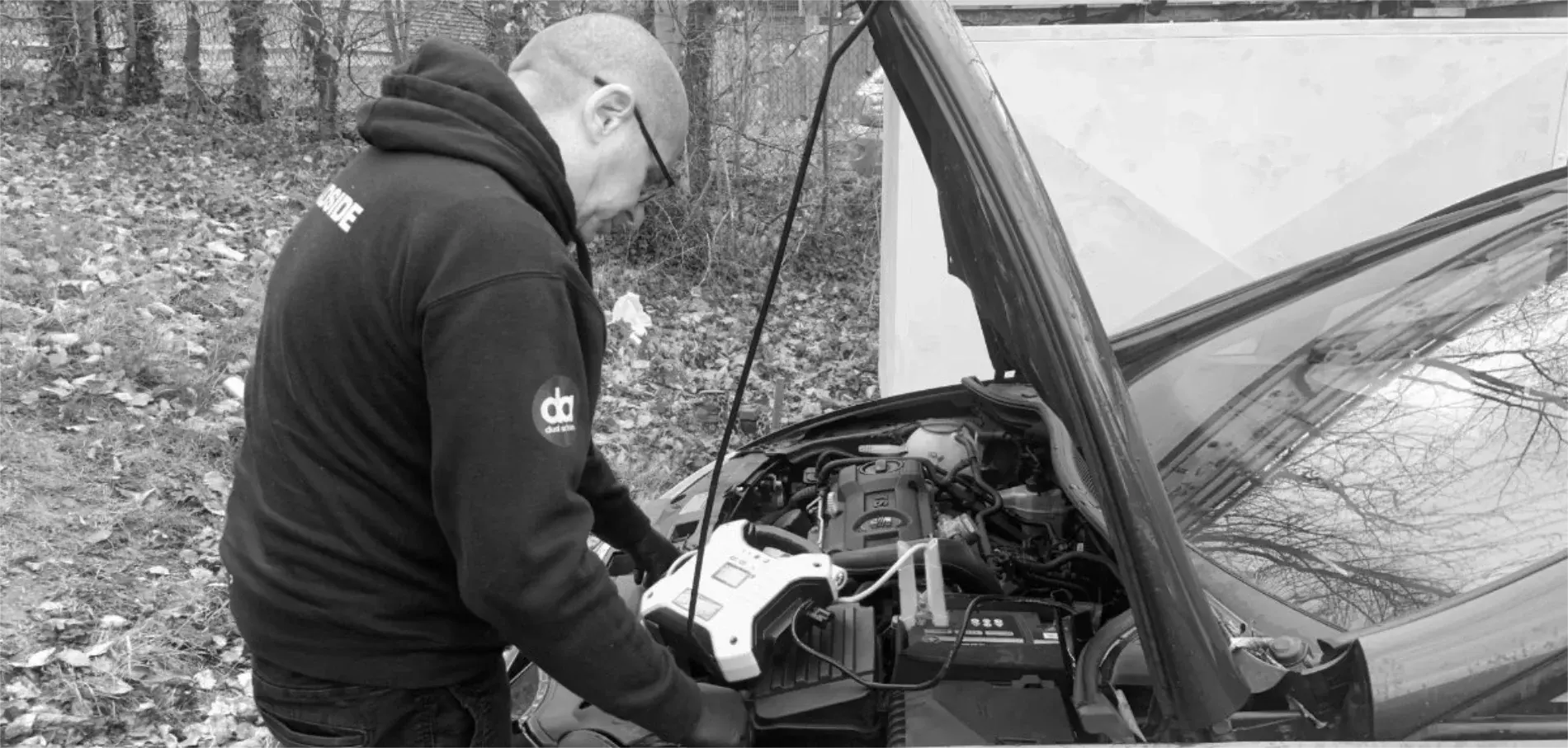 Dual Action technician testing a vehicle battery at the roadside